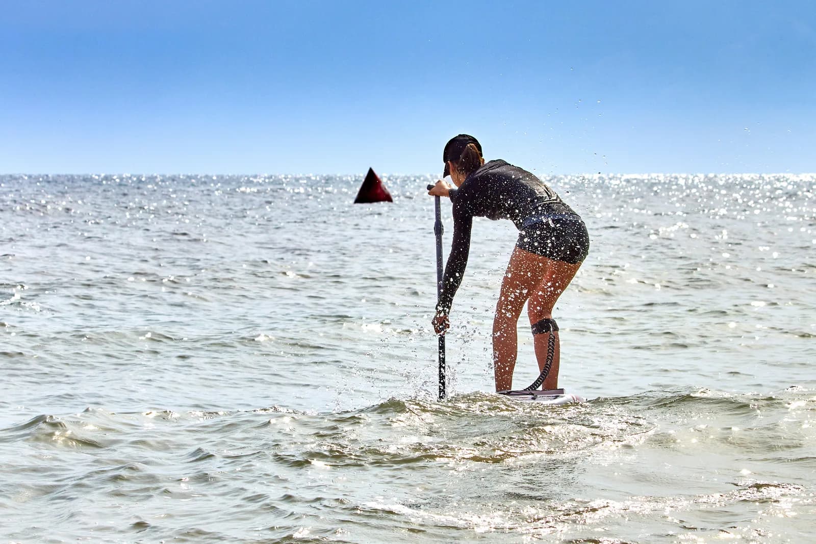 A paddleboarder moving across open coastal water