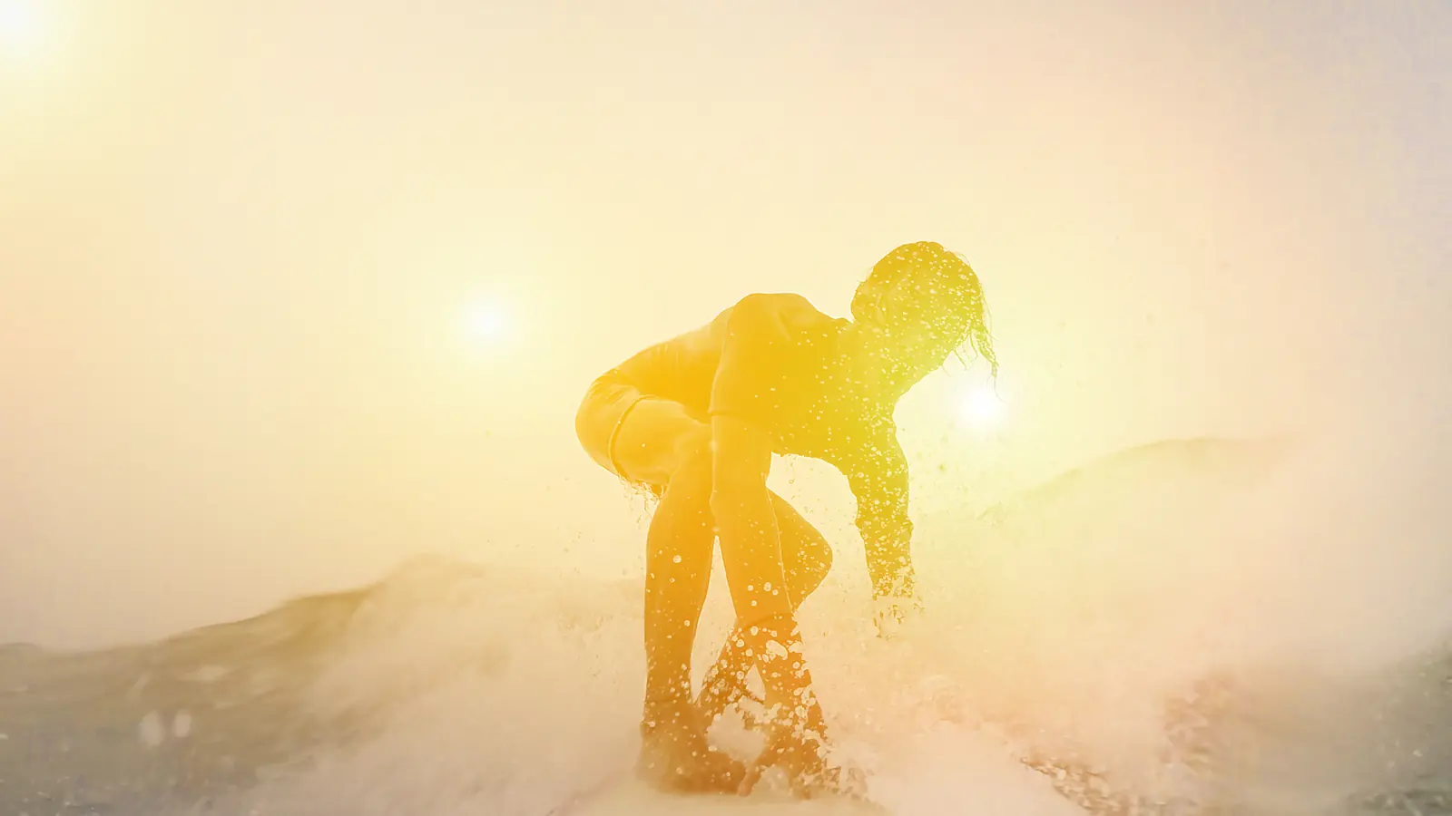 A surfer riding a wave in warm evening light