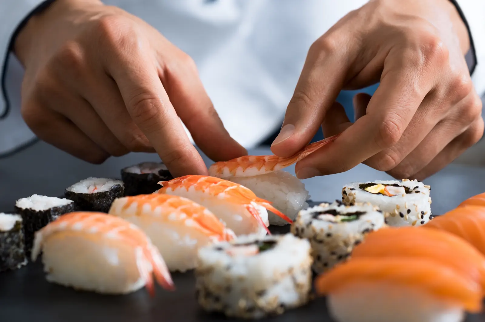 A sushi chef carefully preparing a fresh plate