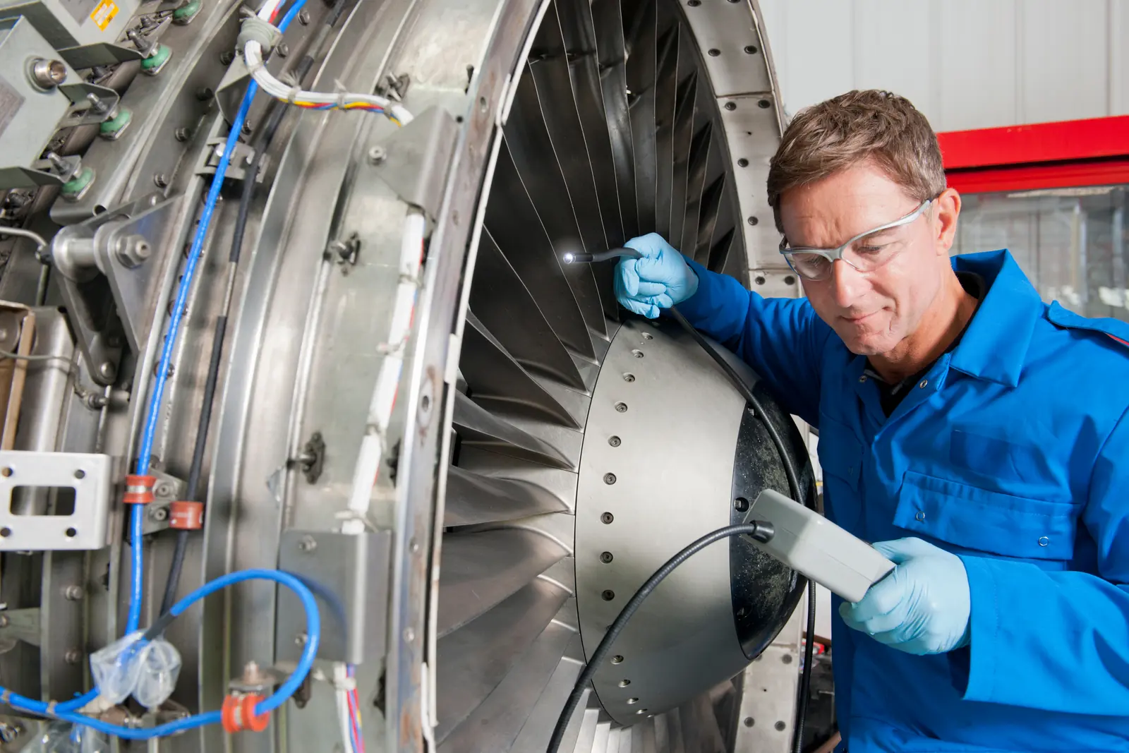 An aerospace engineer inspecting a turbine assembly inside a hangar