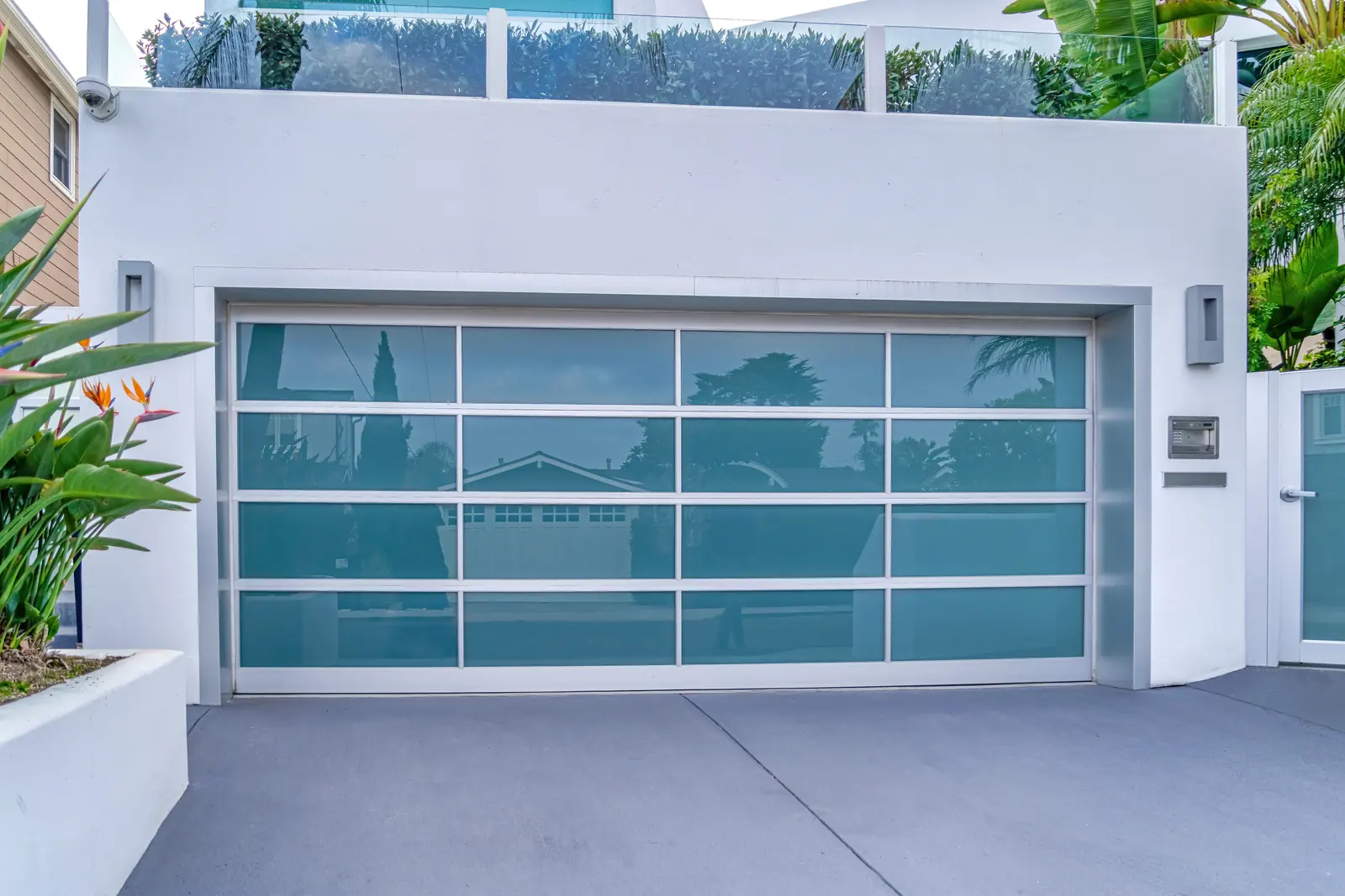 A contemporary Southern California home with a glass garage door and palms