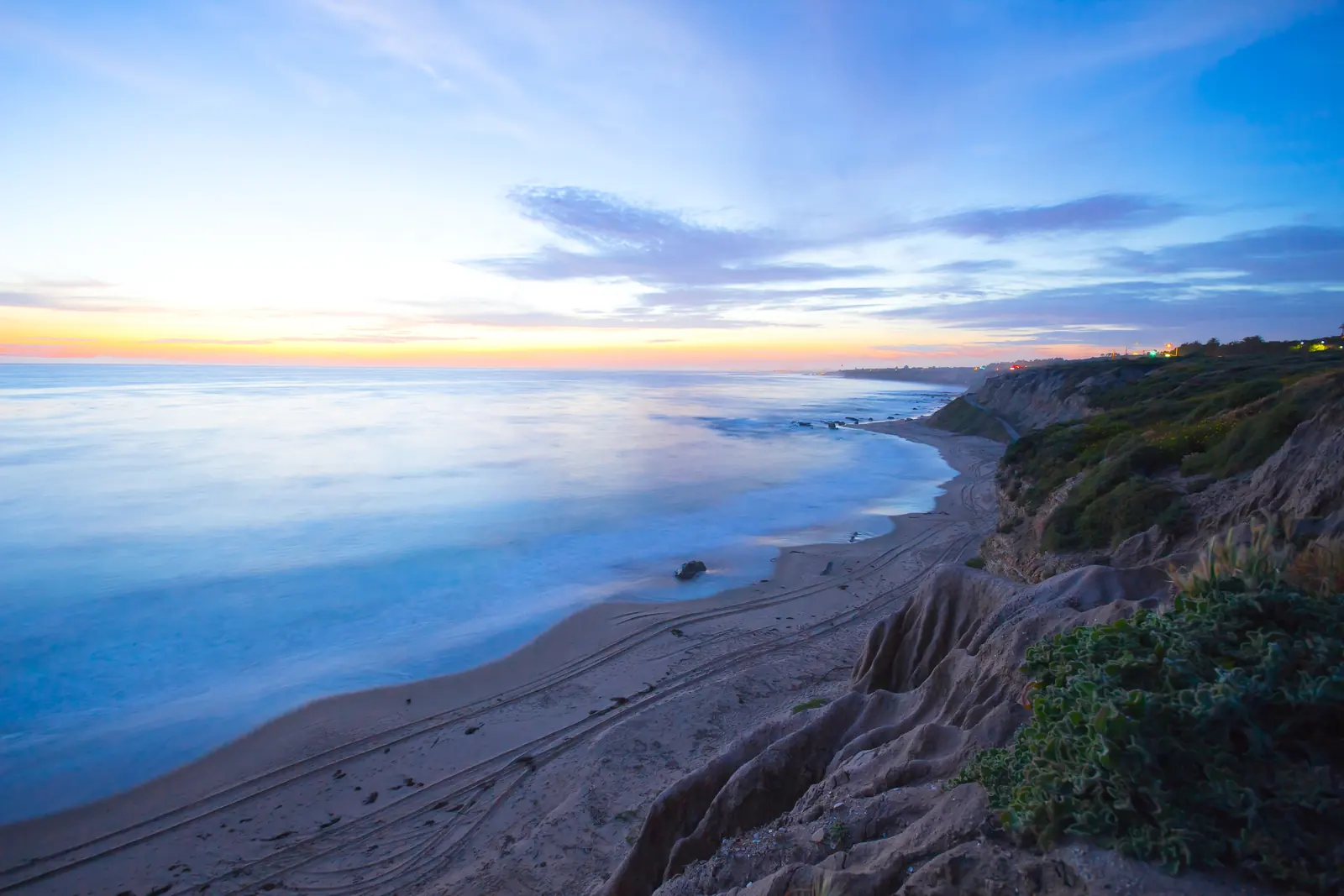 A Southern California coast settling into blue-hour light