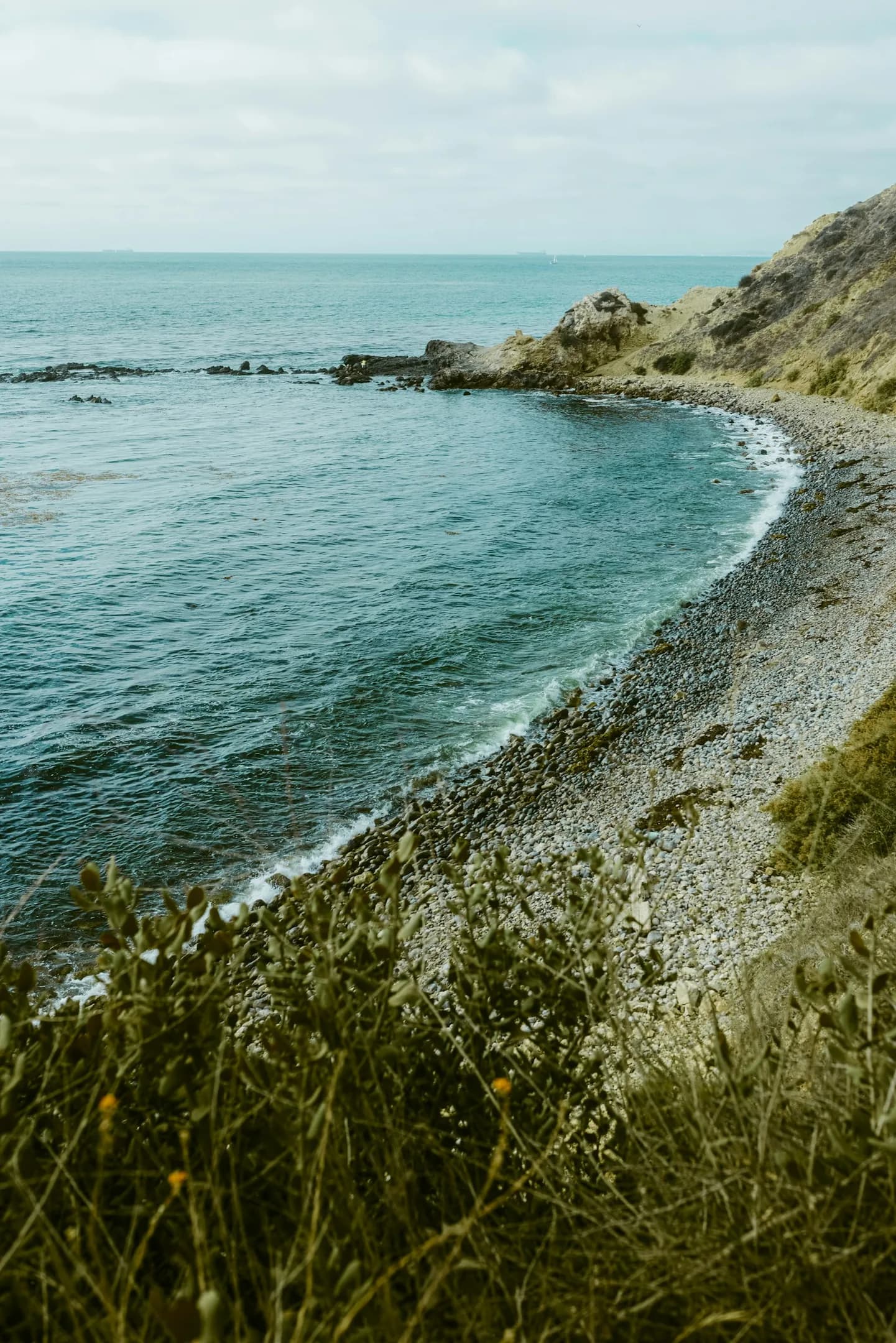 A quiet rocky cove beneath pale coastal light