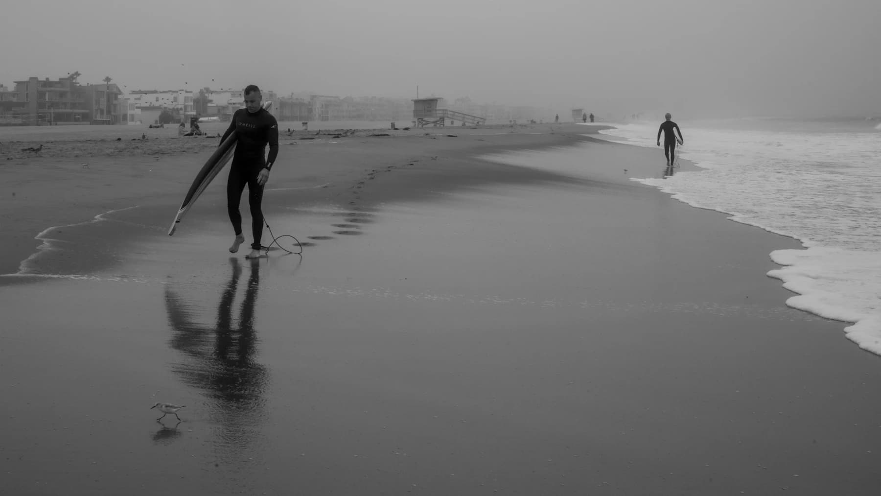 A quiet sandy shoreline with small, gentle surf