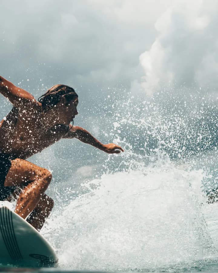 Surfer carving through a breaking wave
