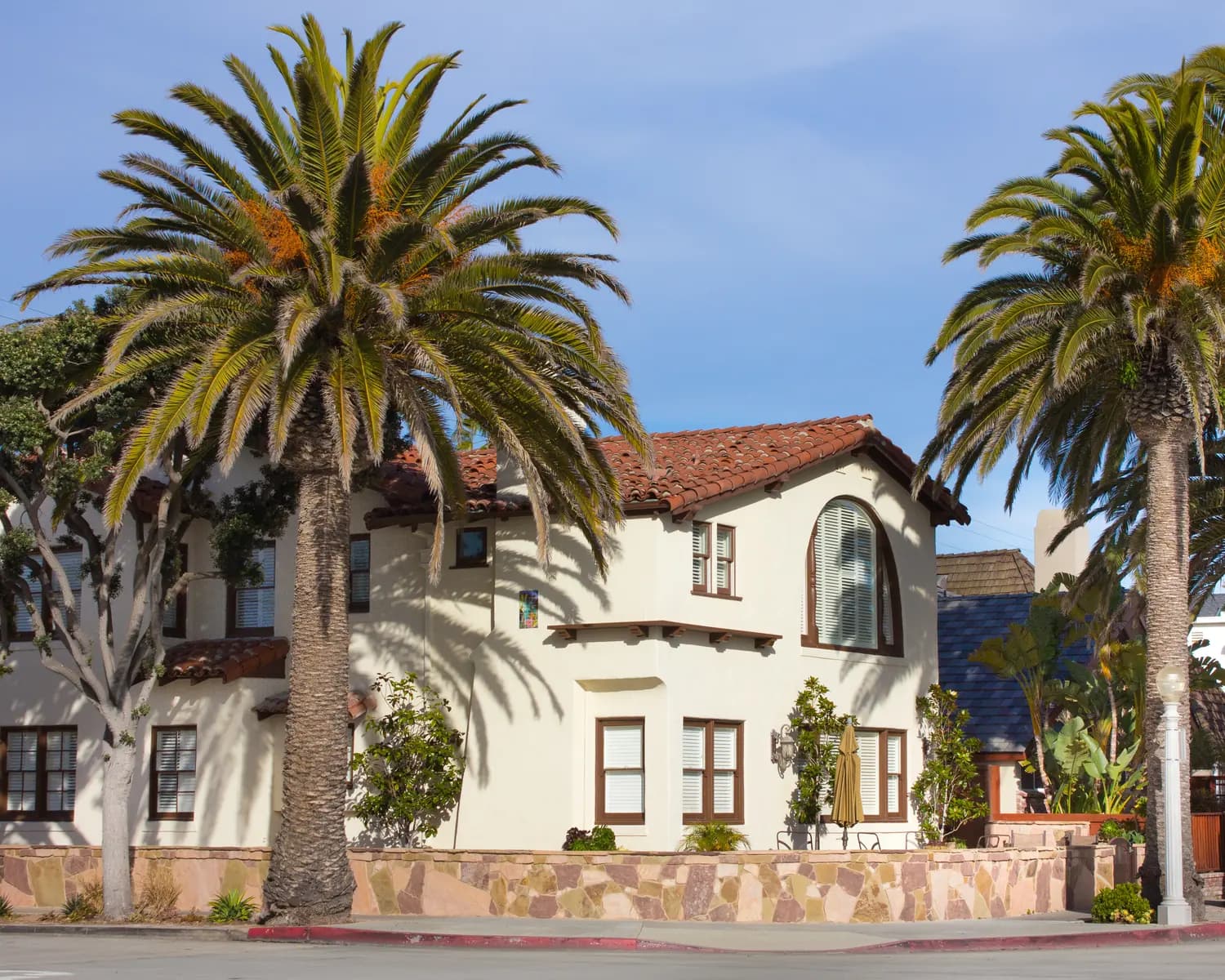 A Southern California home framed by mature palm trees