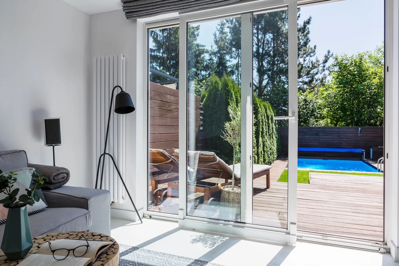 A bright luxury living room opening to a sunny pool terrace