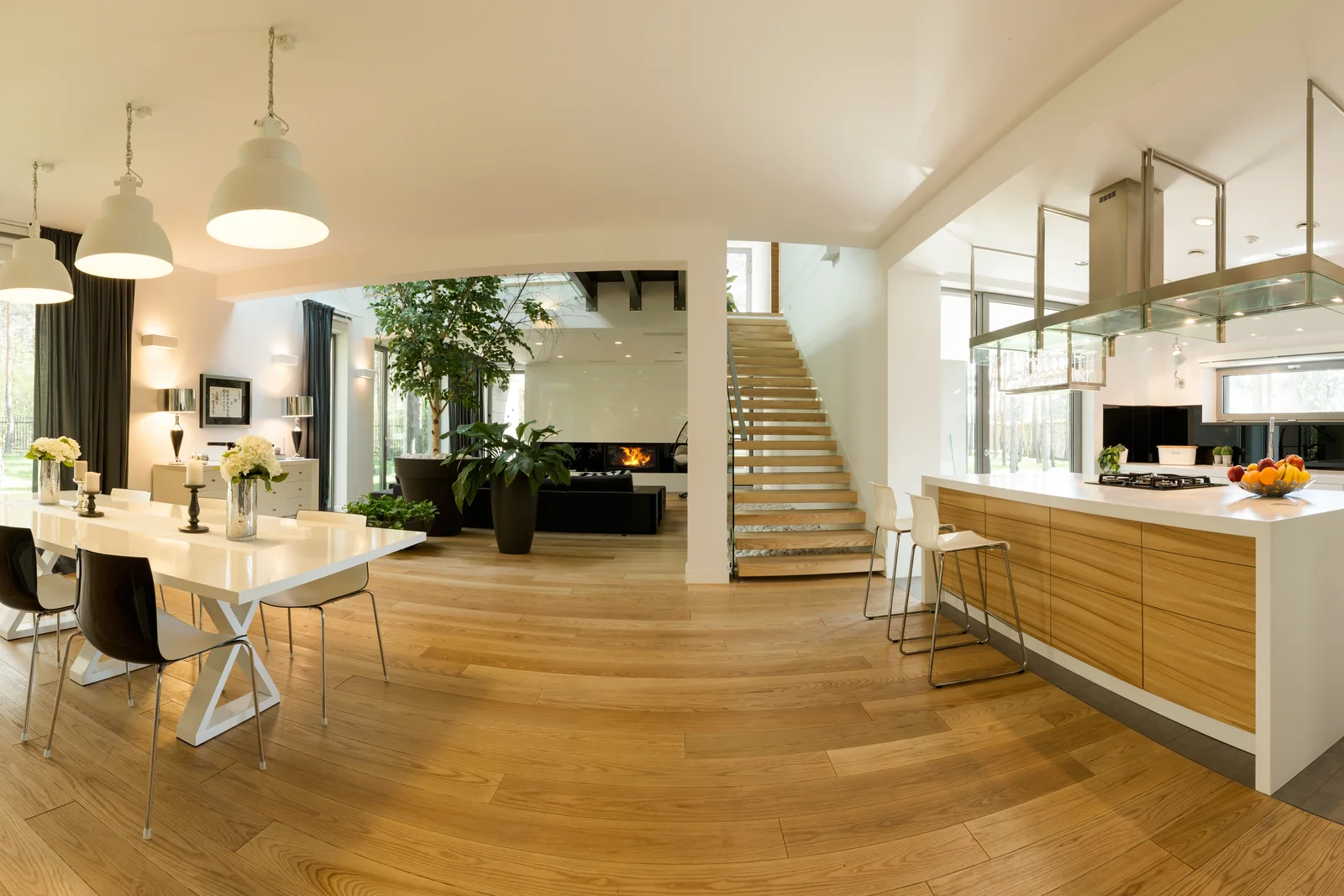 A sunlit open-plan luxury kitchen, dining area, and living room