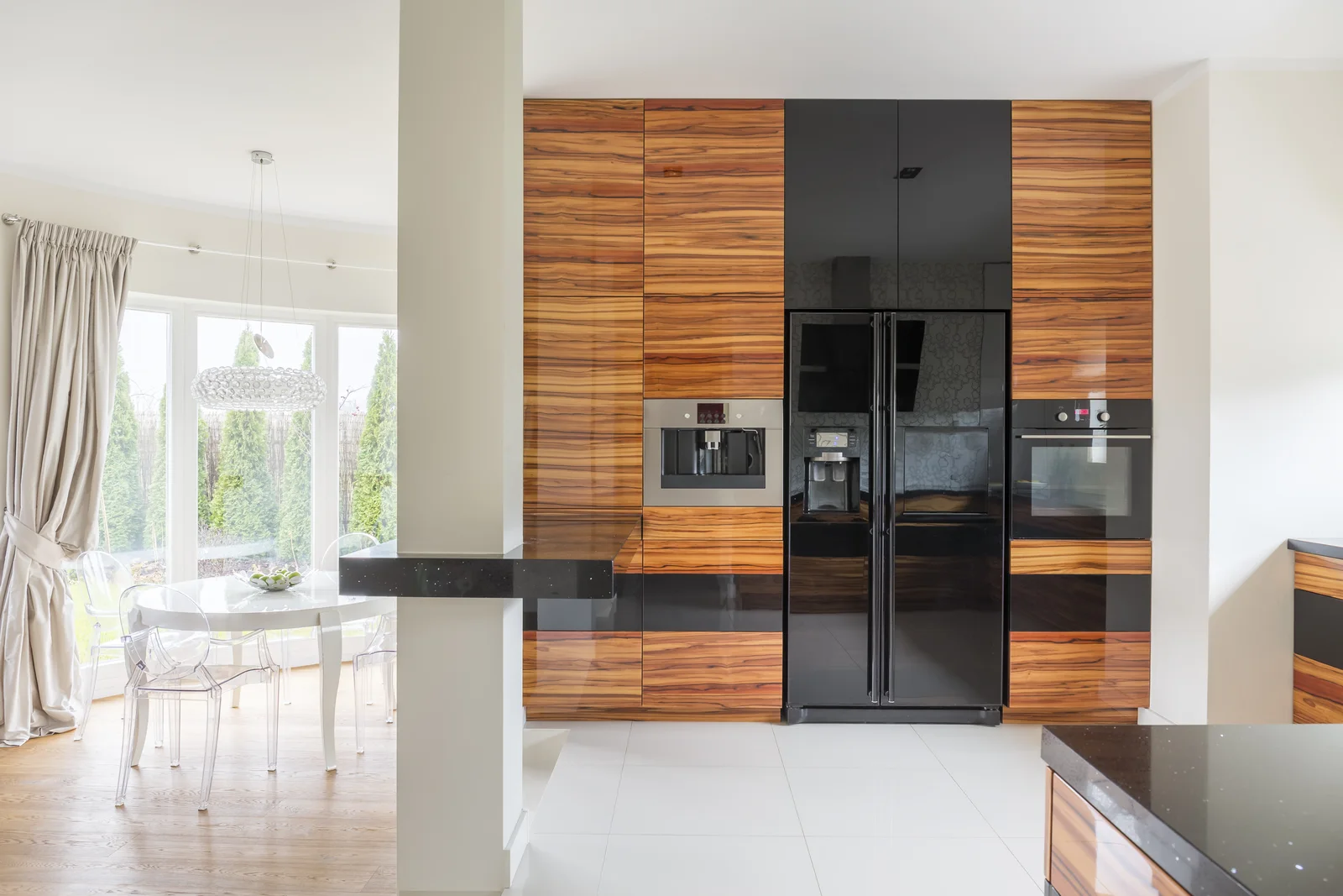 A modern luxury kitchen opening toward a planted patio