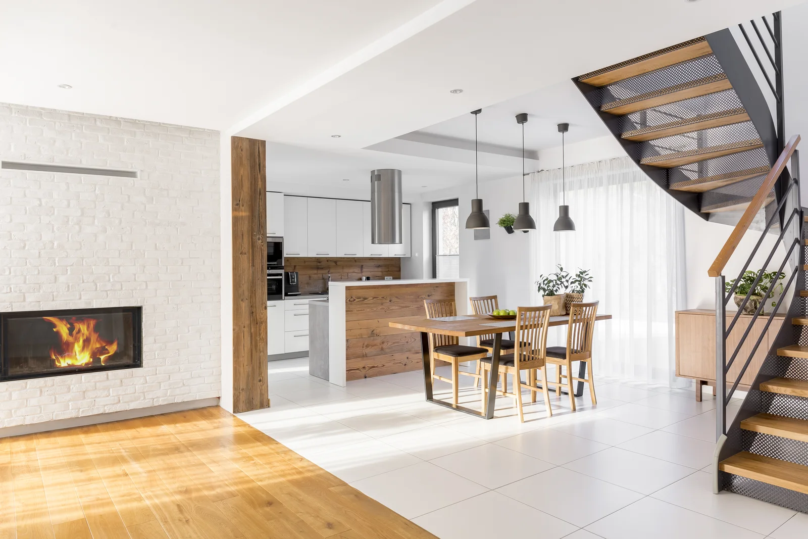 A bright modern kitchen and living area centered on a fireplace