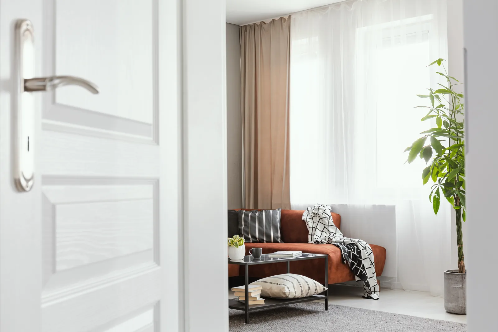 An open door leading into a bright, furnished living room