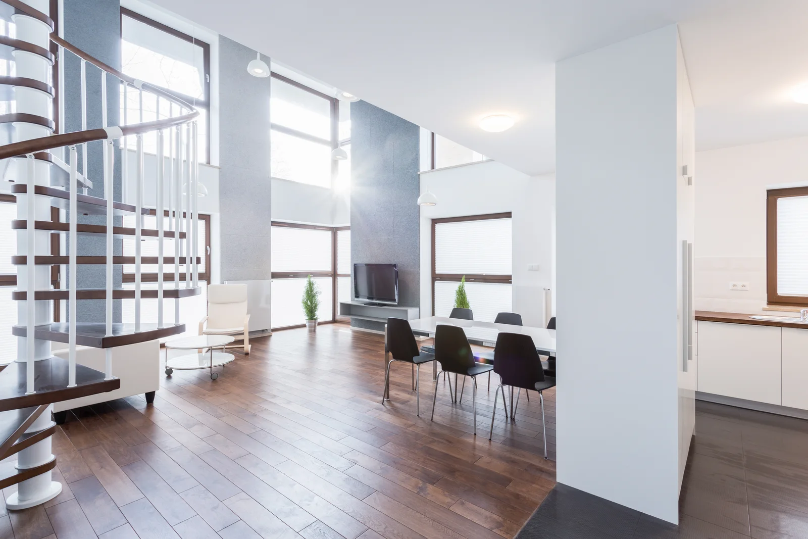 A spacious contemporary living room with open dining and architectural stairs