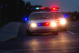 A police SUV facing the camera with its emergency lights illuminated at night